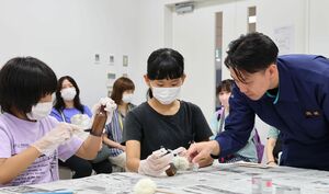 はけを使って指紋を採取する小学生=長岡市大手通2