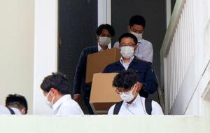 辺野古沖の転覆事故で死亡した船長の関係先から段ボール箱を運び出す海保の職員ら=25日午後、沖縄県南城市