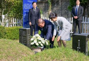 JR新大久保駅転落事故で亡くなった韓国人留学生の李秀賢さんの墓地を参拝し、献花する石破首相。右は妻の佳子さん=30日、韓国・釜山(内閣広報室提供・共同)