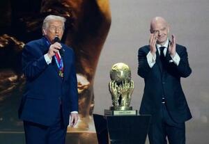 サッカーW杯北中米3カ国大会の組み合わせ抽選会でFIFAが新設した「平和賞」を受賞し、あいさつするトランプ米大統領。右はインファンティノ会長=5日、米ワシントン(共同)