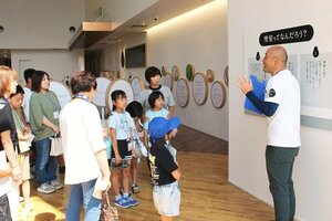 魚沼醸造の担当者から説明を受ける企業探訪ツアーの参加者=5日、魚沼市十日町