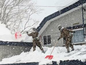 　青森県の災害派遣要請を受け、屋根の雪下ろしをする自衛隊員＝２日午後、青森市（陸上自衛隊第９師団提供）