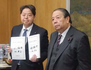 林総務相(左)との引き継ぎ式を終えた村上前総務相=22日午前、総務省