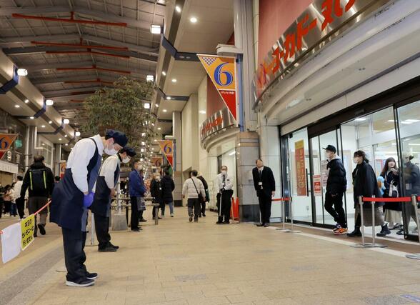 店舗を後にする客らに頭を下げて見送る従業員＝１月２６日午後６時半過ぎ、新潟市中央区