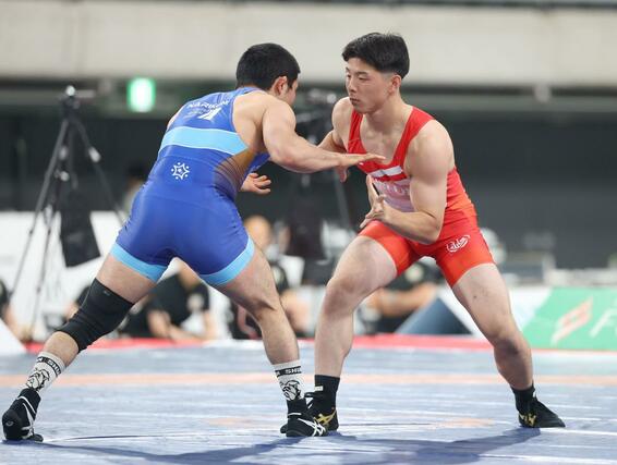 明治杯全日本選抜選手権の男子グレコローマンスタイル７２キロ級プレーオフで相手と組み合う本名一晟（右・赤）＝２０日、東京体育館