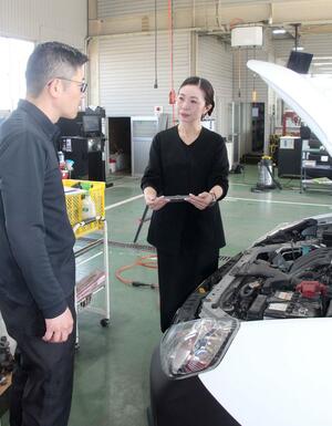 車の点検内容について社員から報告を受ける柴澤仁子さん(右)=五泉市