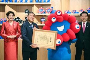 ミャクミャクに感謝状を授与し、記念撮影に応じる石破首相。左は日本館の藤原紀香名誉館長、右は武藤経産相=13日午前、大阪市此花区の夢洲(代表撮影)
