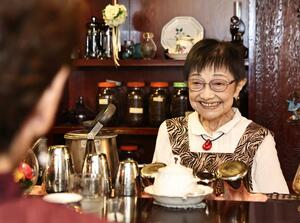 カウンター越しに常連客と談笑する長明子さん=上越市本町4