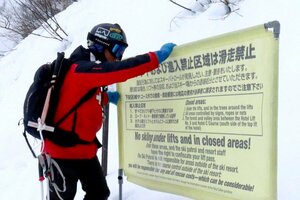 立ち入り禁止区域を示すロープを張る佐藤貴志さん=妙高市の赤倉観光スキー場