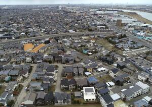 液状化で住宅被害が広範囲に及んだ新潟市西区善久。路上に噴出した砂は片付いていたが、今も電柱が傾いたままの通りもある=3月13日(新潟日報社の小型無人機から撮影)