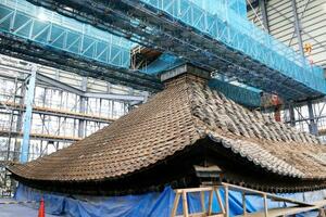 大修理が進む興福寺の五重塔で、報道陣に公開された屋根瓦の解体工事=10日午後、奈良市