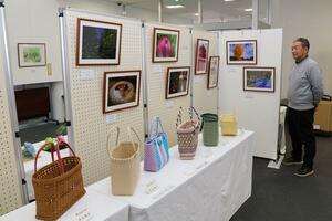 写真や紙ひもクラフトが並んだ新潟日報カルチャースクール三条教室の作品展＝三条市須頃２