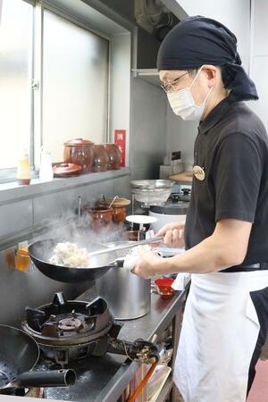 食べる人に「スタミナをつけてほしい」との思いで40年以上「とん丼」を調理する丸田学さん=柏崎市田塚2