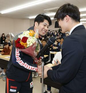 壮行会で学生から花束を受け取る水沼尚輝(左)=新潟市北区