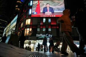 新年を迎える祝辞を発表する中国の習近平国家主席を映す北京市内の大型画面=31日(共同)