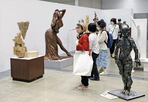 県展新潟展で作品を鑑賞する来場者=5月24日、新潟市中央区万代島の朱鷺メッセ