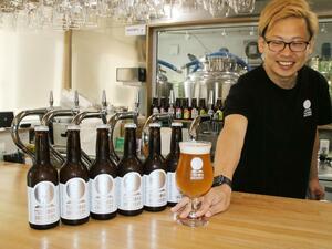 ビールコンテストで金賞を受賞した「月岡ヴァイツェンナチュラル」と新保典司さん=新発田市月岡温泉