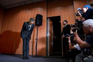記者会見を終え、一礼して引き揚げるサントリーHDの鳥井信宏社長=2日午後、東京都港区