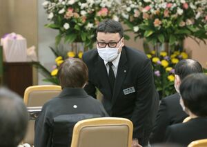 葬儀で遺族に語り掛ける本間義國さん。焼香の案内や司会など役割はさまざまだ=新潟市中央区