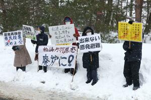 プラカードを掲げて柏崎刈羽原発の起動に反対の意を示す住民＝９日、刈羽村