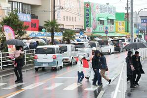 魚の市場通りが買い物客でにぎわう年末に、車が連なった国道４０２号＝２０２５年１２月３０日、長岡市寺泊下荒町