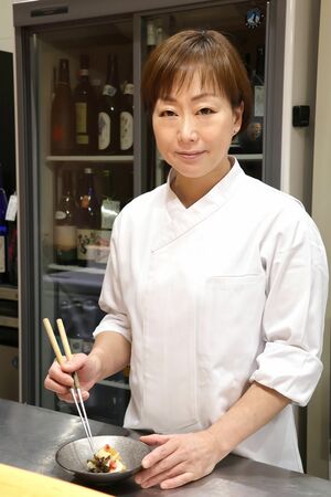 酢の物を盛り付ける弓削朋子さん。「スキー選手の頃は荘厳な風景の中で走るのが好きだった。料理人となった今も、雪の恵みに感謝です」と語った=十日町市駅通り