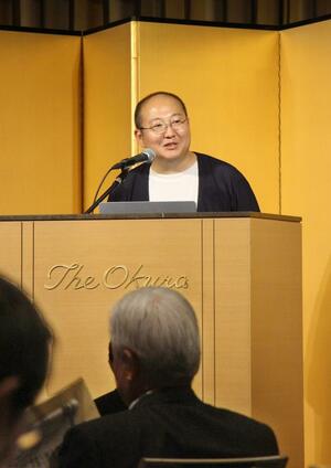 新潟日報生成AI研究所の取り組みを紹介する石山洸所長=27日、東京都港区