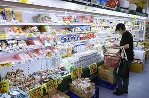 スーパーの商品棚を眺める買い物客＝１月、東京都練馬区