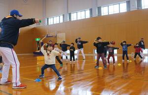 野球教室で投げる動作を練習する子どもたち＝佐渡市梅津