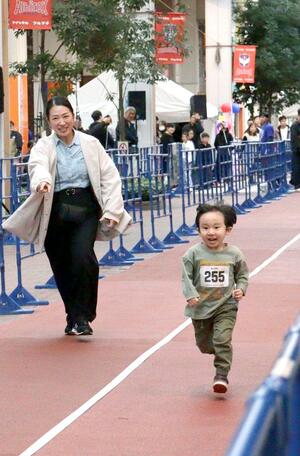 陸上短距離走に親しむ催し「シグナルストリート古町」で、商店街のど真ん中を全力疾走する参加者ら＝新潟市中央区古町通７