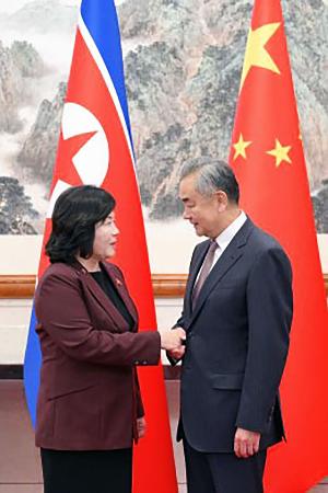 握手する北朝鮮の崔善姫外相(左)と中国の王毅外相=28日、北京(中国外務省のホームページから、共同)