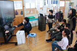 オンラインで交流する高柳小学校の児童と、画面の向こうの酒谷小児童＝柏崎市高柳町岡野町の高柳小学校