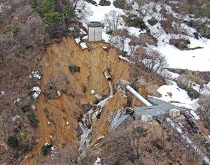 破断した水管(中央)と土砂崩れ現場。右下は倒壊した鉄塔=4月、上越市(県提供)