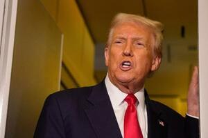 10月30日、米大統領専用機内で記者団に話すトランプ米大統領(ゲッティ=共同)