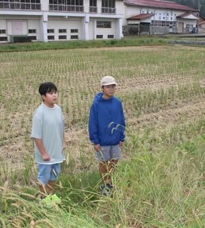 高齢女性が倒れていた水田で、当時の状況を振り返る橘桐真さん(左)と佐藤蒼介さん=魚沼市親柄
