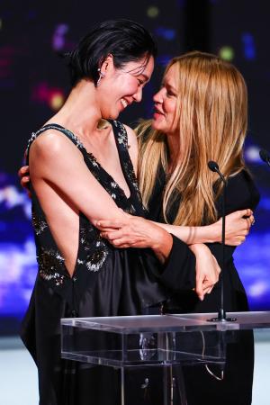 第79回カンヌ国際映画祭の授賞式で、抱き合って喜ぶ岡本多緒さん(左)とビルジニー・エフィラさん=23日、フランス・カンヌ(ロイター=共同)