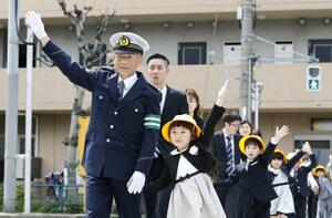 　新１年生と手をつないで横断歩道を渡る警視庁の筒井洋樹警視総監（手前左）＝６日午後、東京都大田区