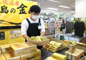 商品の品出し作業を行う小野寺諒さん=佐渡市両津湊