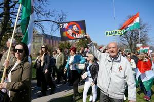 プラカードを掲げるハンガリーの与党「フィデス・ハンガリー市民連盟」の支持者ら=15日、ブダペスト(共同)