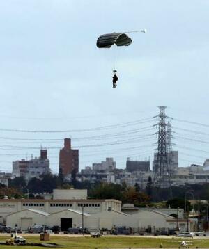 沖縄県の米軍嘉手納基地で実施したパラシュート降下訓練で着地する米兵=3日午後1時