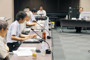 小原徹座長(右奥)の再任に反対を表明する豊島剛志委員(左から2人目)=25日、新潟市中央区