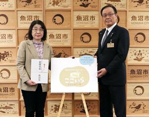 「ここいら(cocoira)」のロゴを囲む島野由美さん(左)と内田幹夫市長=3月19日、魚沼市役所