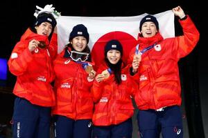 　混合団体で銅メダルを獲得し、笑顔で日の丸を掲げる（左から）二階堂蓮、丸山希、高梨沙羅、小林陵侑＝プレダッツォ（共同）