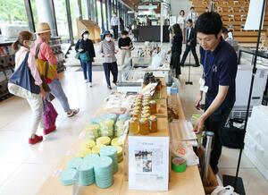 佐渡産の多彩な商品を買い求める人でにぎわうマルシェ=7月12日、新潟市中央区万代3