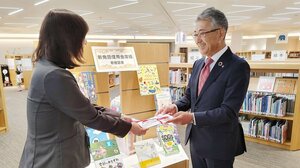 新発田市立中央図書館で目録を手渡す荒井一夫理事長(右)=新発田市諏訪町1