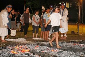 スギの葉などを燃やした灰の上を歩く参加者=長岡市谷内2
