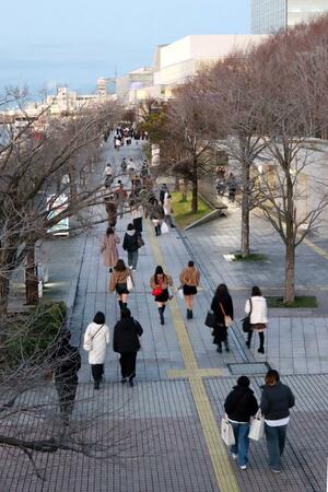 ライブ会場の朱鷺メッセに向かうファン。新潟駅から直行する人が目立った＝２０２５年１２月、新潟市中央区