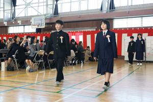 緊張の面持ちで入場する卒業生たち＝１８日、新潟市西区