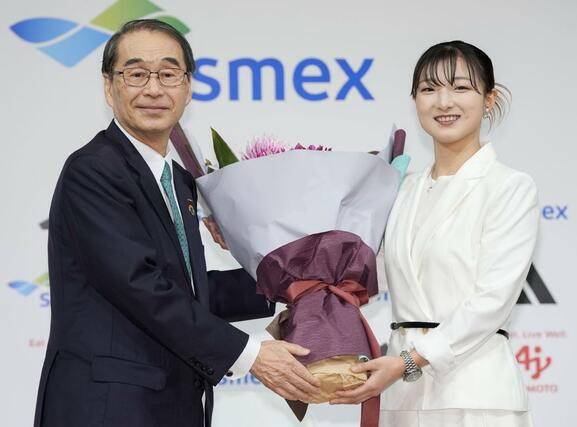 現役引退の記者会見で、花束を受け取るフィギュアスケート女子の坂本花織（右）＝１３日午前、神戸市内のホテル