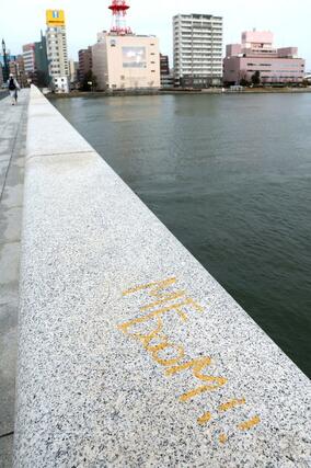 萬代橋で見つかった落書き。橋の欄干に黄色の塗料で書かれていた